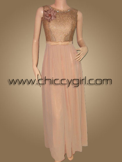 ชุดราตรียาวสีทอง คอกลมขอบลูกไม้ปักมุก แขนกุด ผ้าลูกไม้ถักไหมเงามันลายใบไม้ ประดับเลื่อม ตกแต่งเข็มกลัดดอกไม้ที่อก เอวแต่งโบว์ซ้อน 2 ชั้น กระโปรงผ้าชีฟองพริ้ว แบบสวย สุภาพ เรียบร้อย น่ารัก หรูหราสง่างามมาก