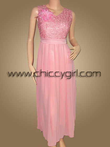 ชุดราตรียาวสีชมพู คอวี แขนกุด ผ้าลูกไม้ถักไหมเงามันลายดอกไม้ ประดับเลื่อม ตกแต่งเข็มกลัดดอกไม้ที่อก กระโปรงผ้าชีฟองพริ้ว แบบสวย สุภาพ เรียบร้อย น่ารัก หรูหราสง่างามมาก